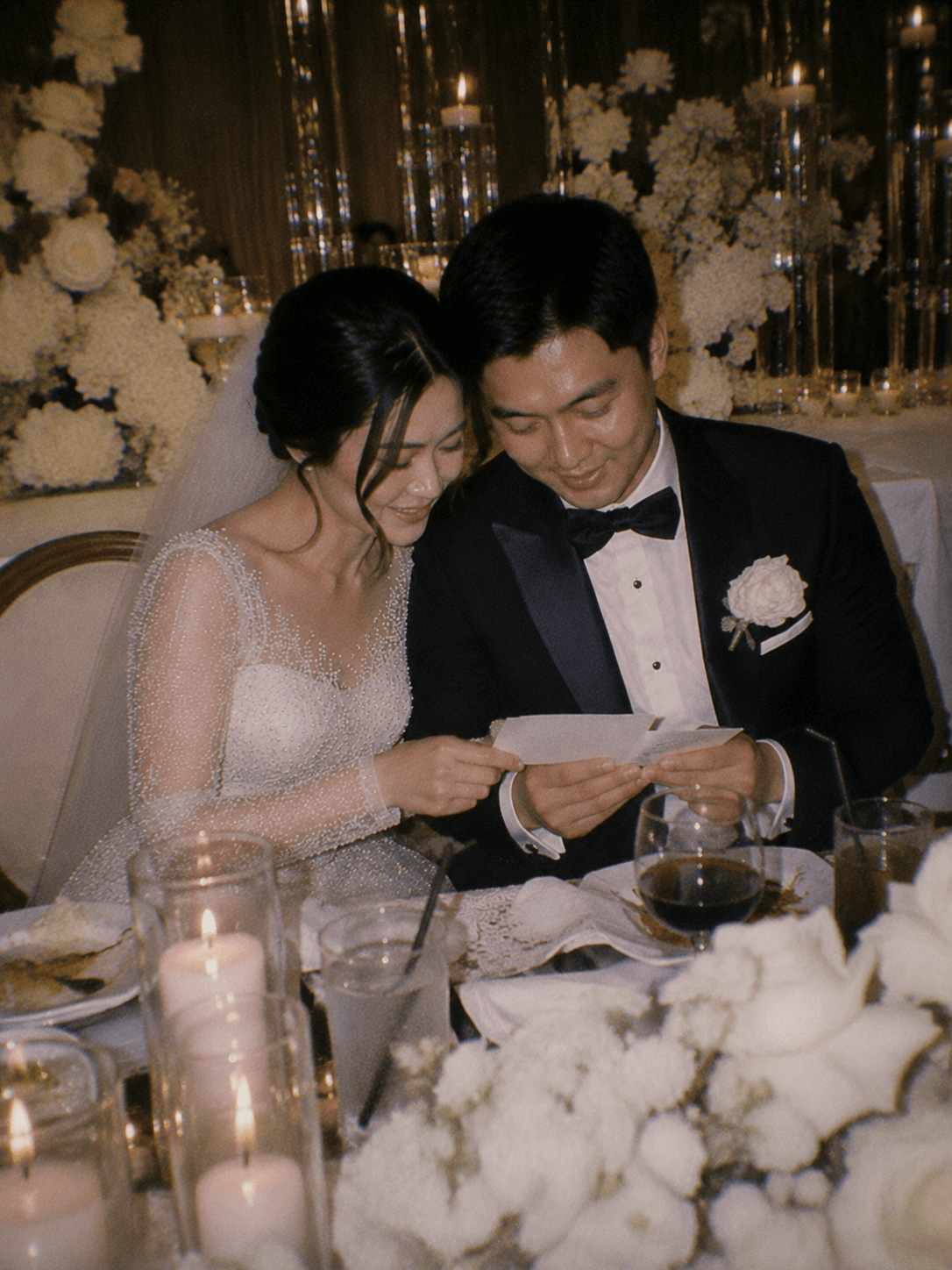 Pengantin membaca surat bersama di meja resepsi