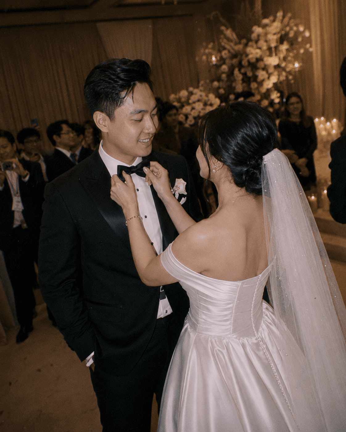 Pengantin wanita merapikan dasi kupu-kupu pengantin pria